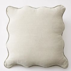 a white pillow with silver piping on the front and back of it, against a white background