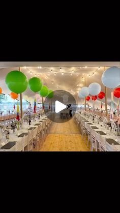 a large room filled with lots of tables covered in white tablecloths and balloons