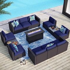 an outdoor furniture set with blue cushions on a deck next to a pool and palm tree