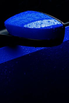 a close up of a blue object with water droplets on it