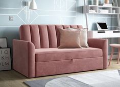 a living room with a pink couch and white table in the corner next to it