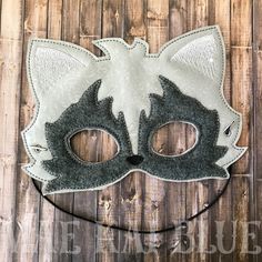 a white and black cat mask sitting on top of a wooden floor