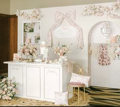 a room decorated in pink and white with flowers on the wall