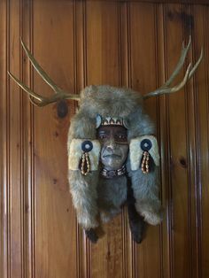 a deer's head mounted to the side of a wooden wall