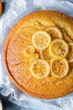 a cake with sliced lemons on top and some orange juice in the back ground