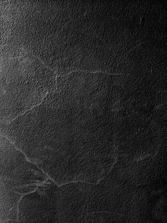 a black and white photo of a wall with cracks in the concrete, as seen from above