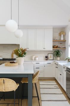 a kitchen with white cabinets and an island in front of the stove top is shown