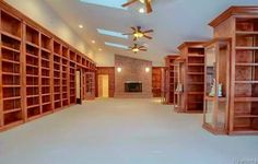 an empty room with lots of bookshelves and ceiling fans