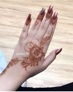 a woman's hand with henna on it and flowers painted on the palm