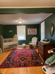 Baby nursery with green walls and vintage touches Persian Rug Nursery, Dark Wood Boho Nursery, Green And Walnut Nursery, Green And Rust Nursery, Green And Orange Nursery Gender Neutral, Green And Brown Nursery Gender Neutral, Dark Green Nursery, Nursery Rugs Boy, Vintage Nursery Boy