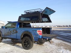 the truck is parked in the snow with its roof open