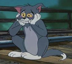 a cartoon cat sitting on the ground with its hands in his mouth