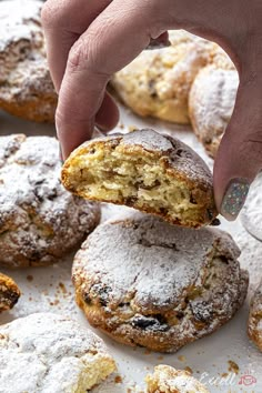 a person picking up some powdered sugar from a cookie