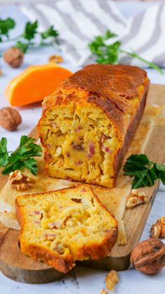 a loaf of bread sitting on top of a wooden cutting board next to an orange