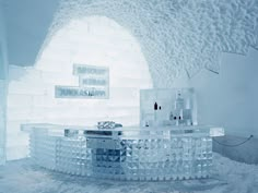 an ice hotel with a bar and sink in the middle, surrounded by white snow