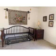 a bedroom with a bed, dresser and pictures on the wall