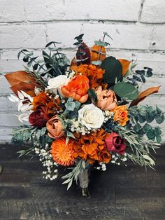 a bouquet of flowers sitting on top of a wooden table