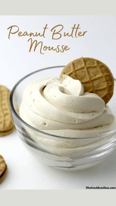 a bowl filled with whipped cream next to cookies