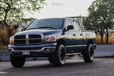 a blue dodge ram truck parked in a parking lot