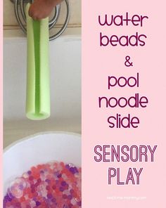 a bathtub filled with lots of pink and purple beads next to a green toothbrush