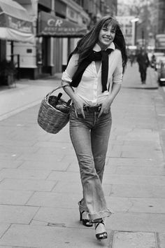 a woman is walking down the street carrying a basket