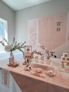 a table topped with pink cakes and cupcakes