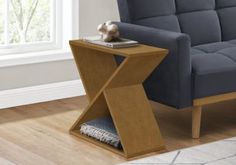 a blue couch sitting next to a wooden table on top of a hard wood floor