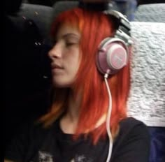 a woman with red hair wearing headphones