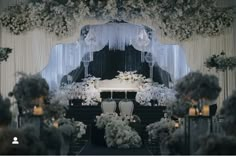 an image of a wedding ceremony setting with flowers and candles on the alter, surrounded by floral arrangements