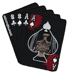 four playing cards with the ace and spades on each card are embroidered onto black fabric