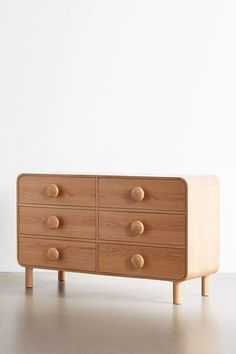 a wooden dresser sitting on top of a white floor