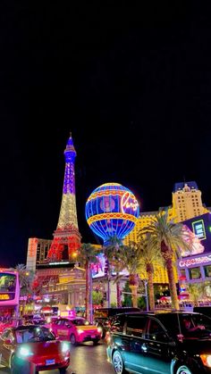 the las vegas strip is lit up at night with neon lights and cars driving down the street