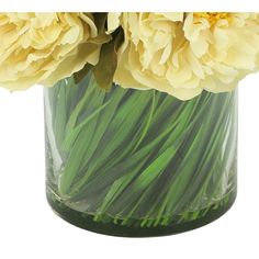 yellow flowers are in a clear vase with green grass on the bottom and long stems sticking out of it