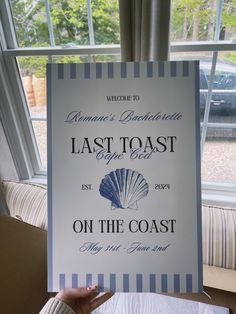 a woman holding up a sign in front of a window that says, last toast on the coast