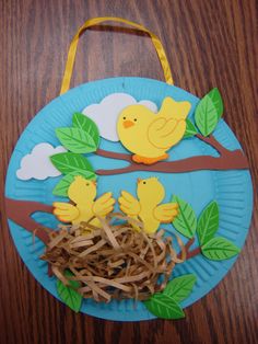 a paper plate that has some birds on it and grass in the middle with leaves