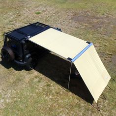 an off - road vehicle with a canopy attached to it in the middle of a field