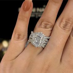 a woman's hand with a diamond ring on it and an engagement band around her finger