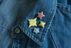 two yellow and white stars are in the lapel of a blue jean jacket,