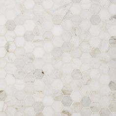 a white marble tile wall with hexagonal tiles