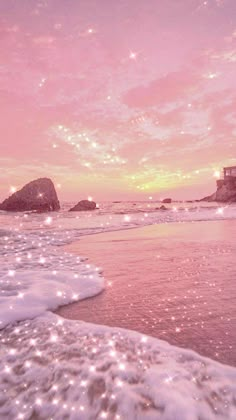 the beach is covered in sparkling water and rocks as the sun sets over the ocean