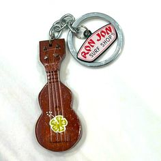 a wooden ukulele keychain with a metal ring