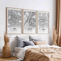 three framed maps hanging on the wall above a bed