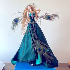 there is a figurine that looks like a woman with peacock feathers on it