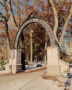 the entrance to central park in winter with snow on the ground and trees behind it