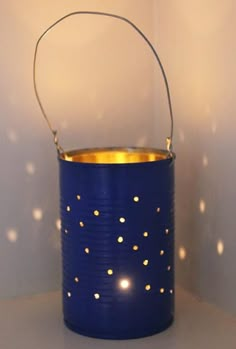 a blue tin can with gold dots on it and a light shining in the background