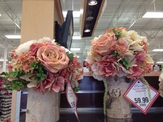 two vases with flowers on display in a store