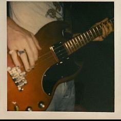 a person holding an electric guitar in their hand