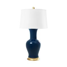 a blue lamp with a white shade on it's side and a gold base