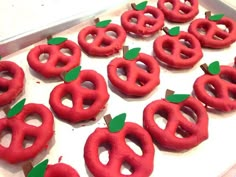 there are many red donuts with green leaves in the shape of apples on them