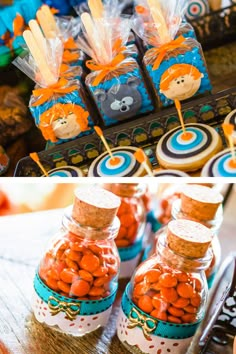 an assortment of candies are displayed in glass jars on a table with orange and blue decorations